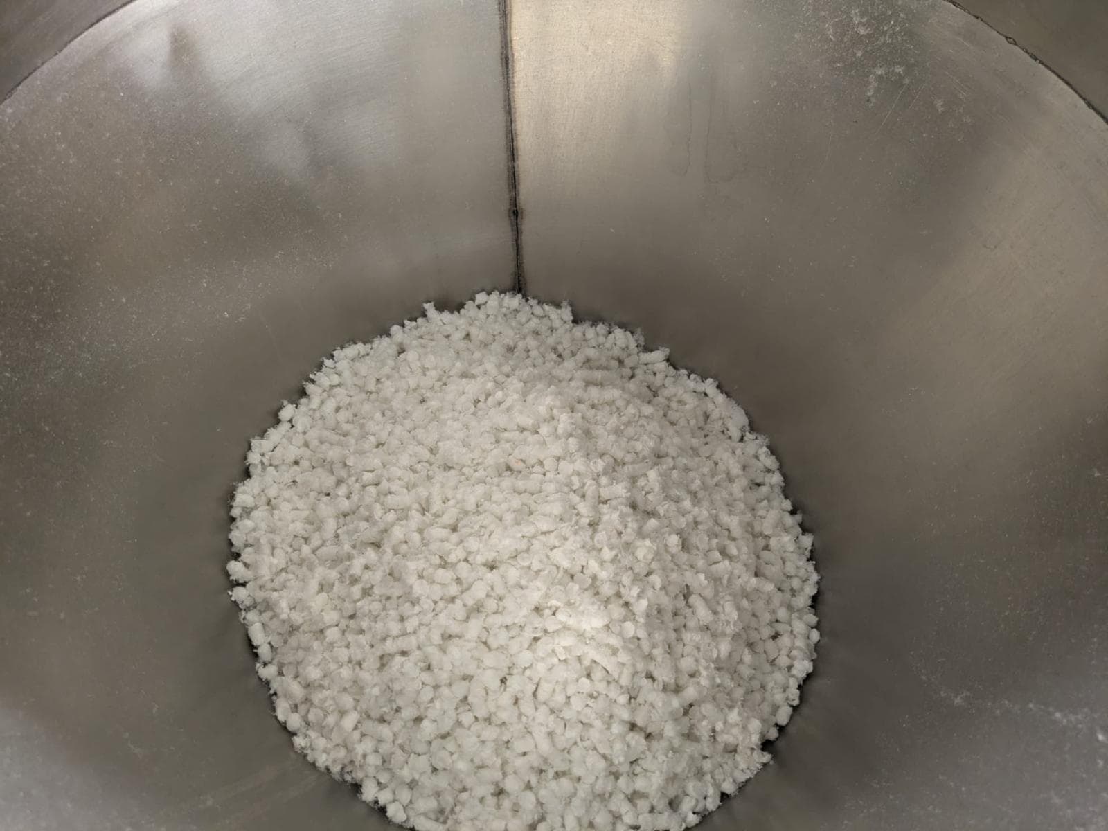 Matière textile blanche broyée dans une cuve industrielle